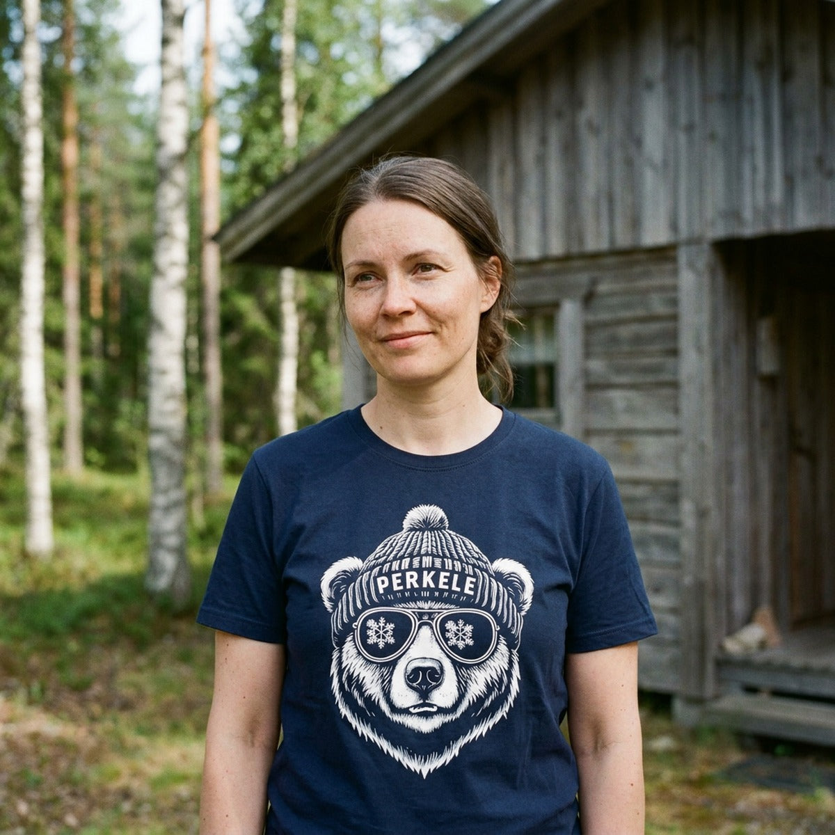 Woman by a Finnish summer cabin wearing the navy Perkele Bear t-shirt, Very Finnish Problems