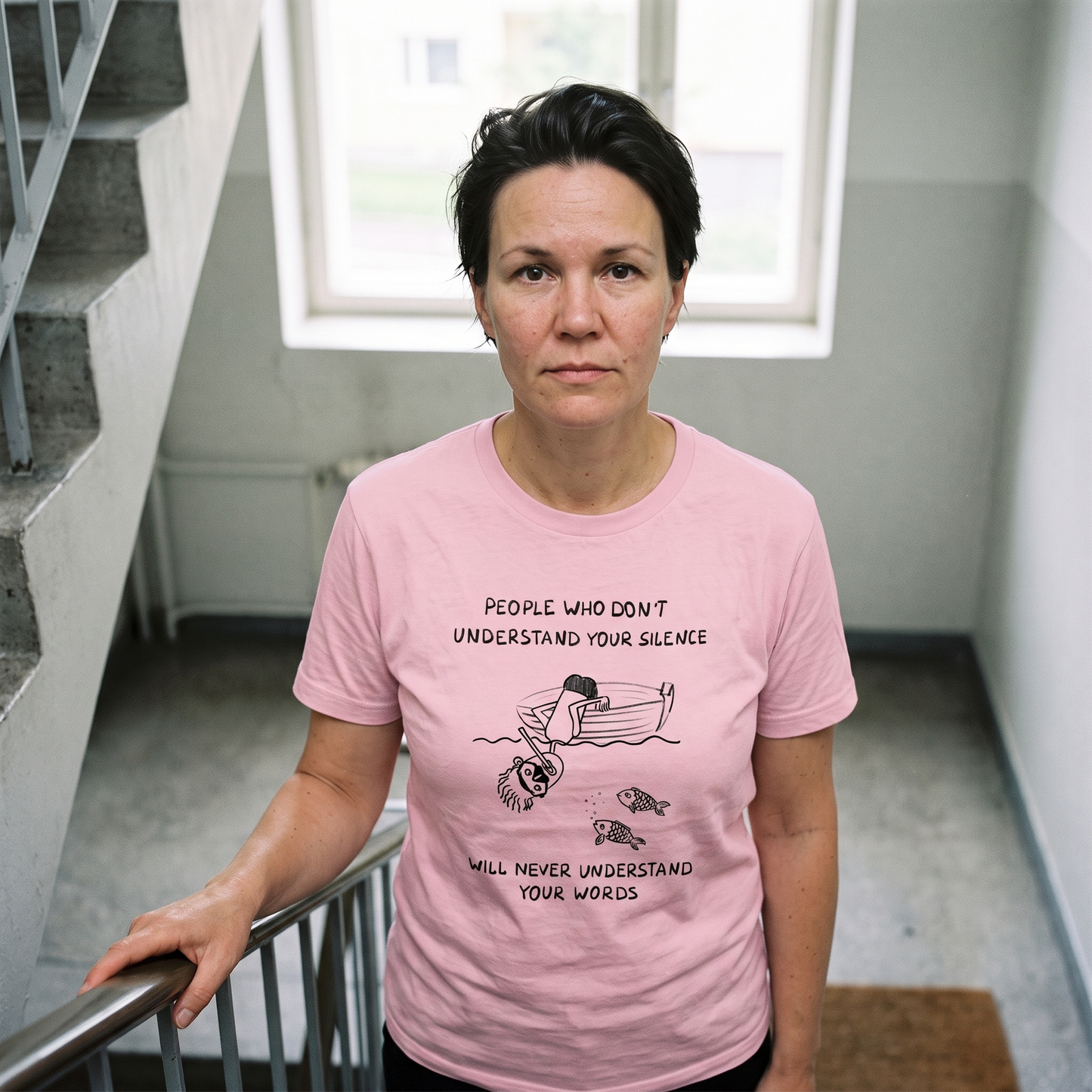 People Who Don't Understand Your Silence t-shirt in light pink, worn by a woman in a stairwell, Very Finnish Problems