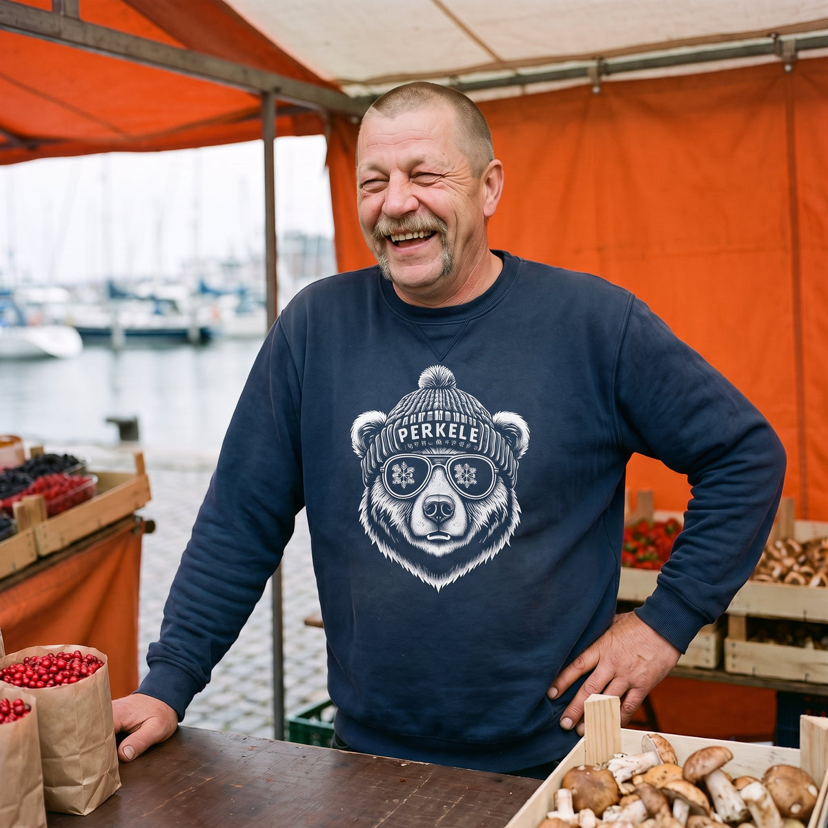Perkele Bear sweatshirt in navy, worn by Juha laughing at a harbour market stall, Very Finnish Problems