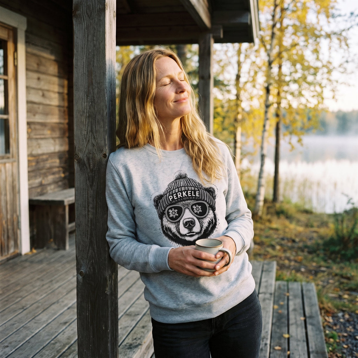 Perkele Bear sweatshirt in sport grey, worn by Elina with a morning coffee on a cottage porch, Very Finnish Problems