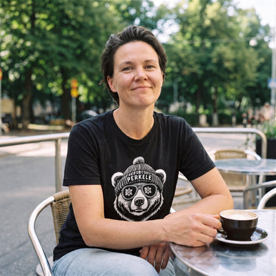 Perkele Bear t-shirt in black, worn by Katja at a Helsinki café terrace in summer, Very Finnish Problems