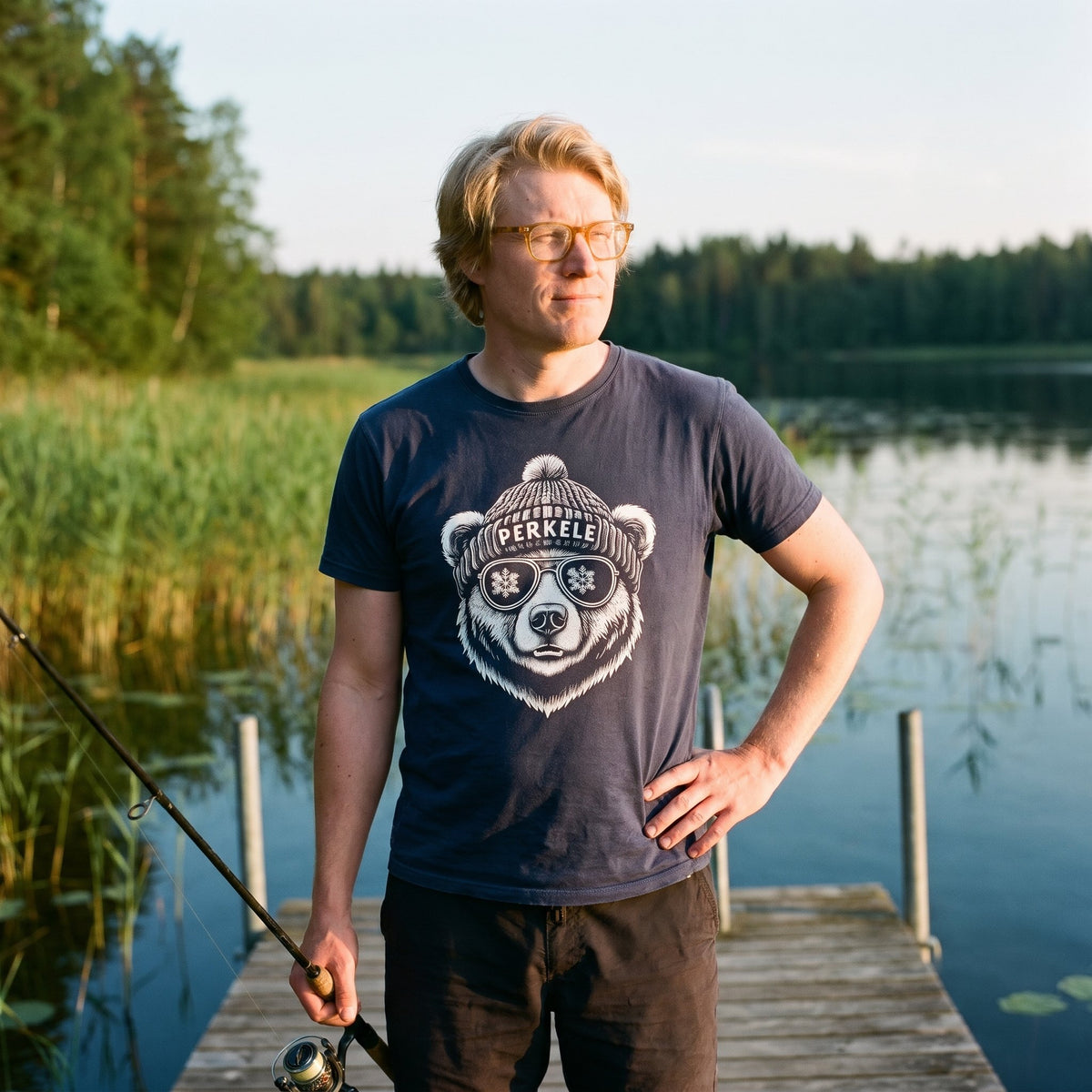 Perkele Bear t-shirt in navy, worn by Tuomas fishing from a lake jetty, Very Finnish Problems