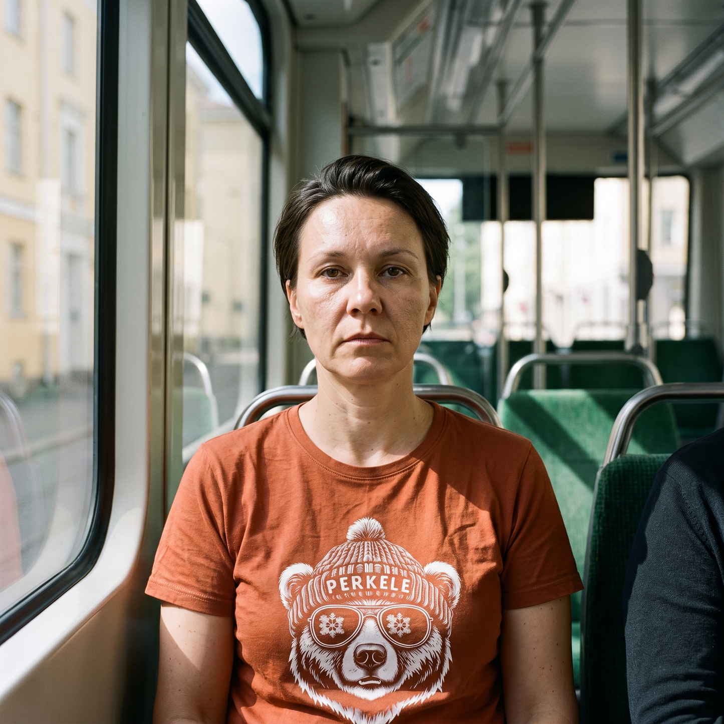 Perkele Bear t-shirt in burnt orange, worn by a woman on a Helsinki tram, Very Finnish Problems