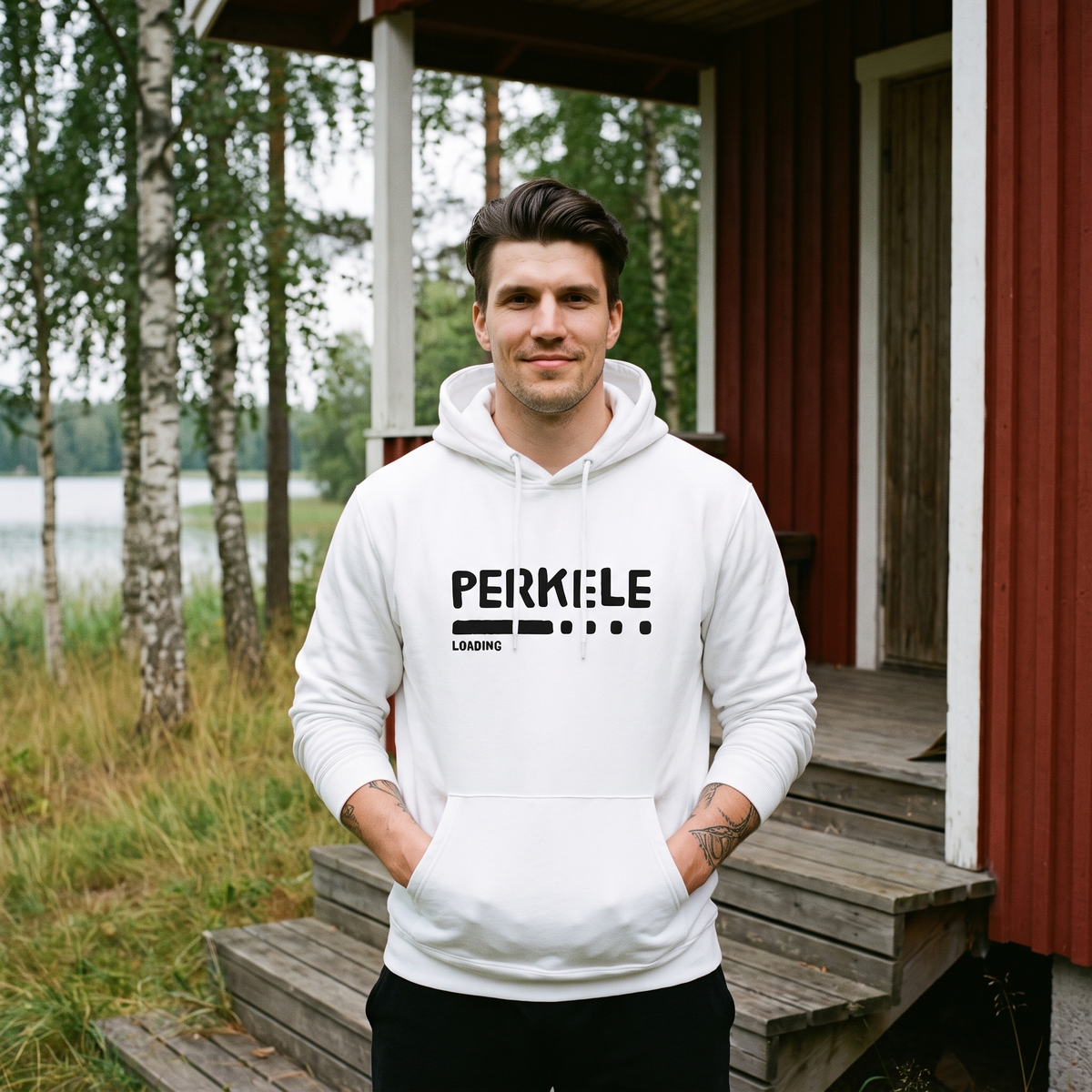 Perkele loading Finnish language hoodie in white, worn by Eetu outside a red summer cottage, Very Finnish Problems