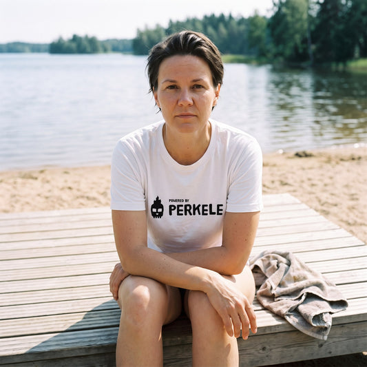 Powered by Perkele organic t-shirt in white, worn by Katja on beach sauna steps, Very Finnish Problems
