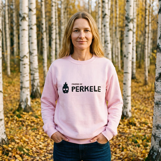 Powered by Perkele sweatshirt in light pink, worn by Elina in an autumn birch forest, Very Finnish Problems