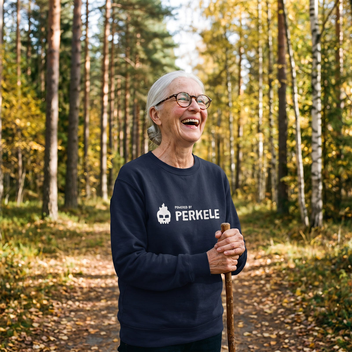 Powered by Perkele sweatshirt in navy, worn by Raija laughing on a forest path, Very Finnish Problems