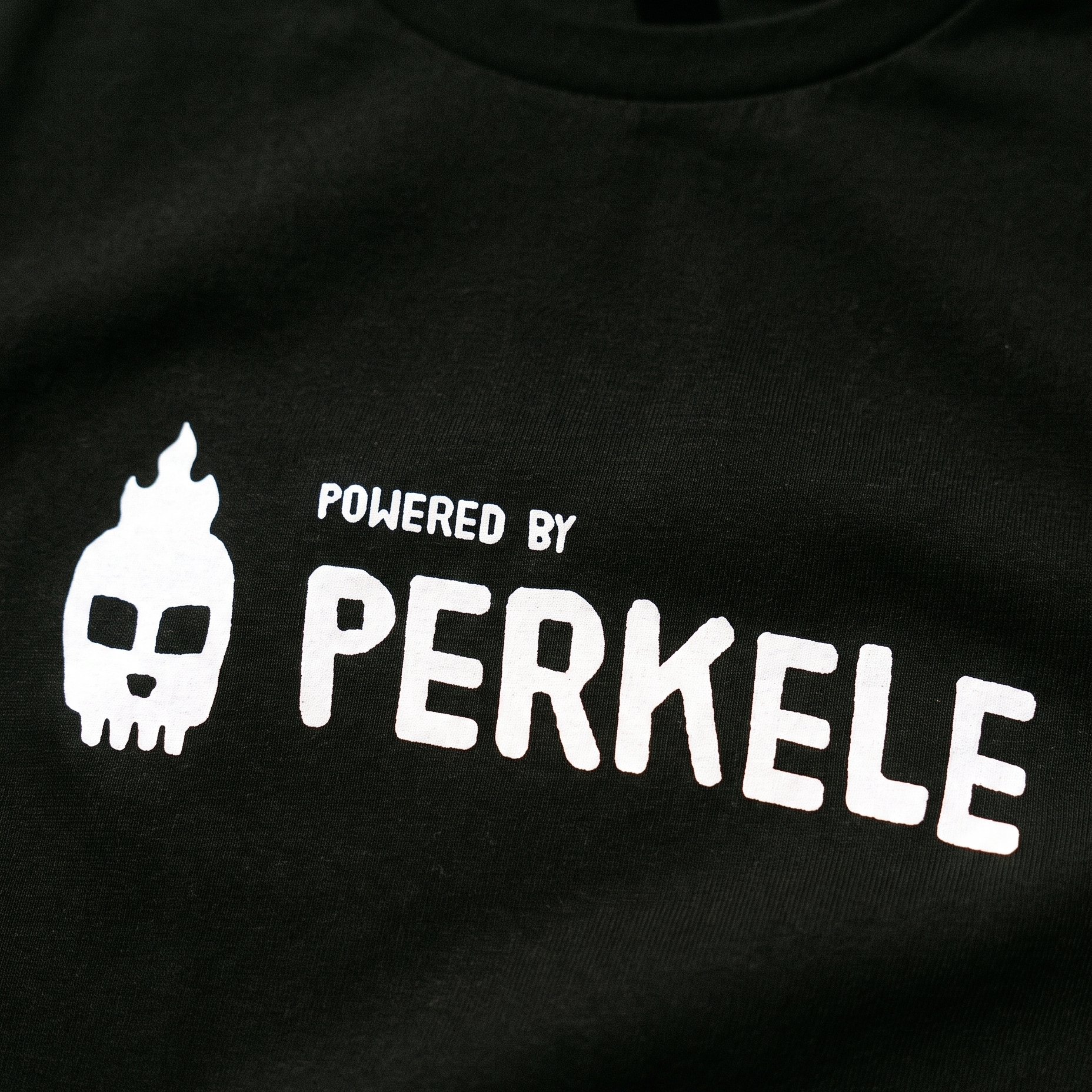 Powered by perkele print close up on black cotton, Very Finnish Problems