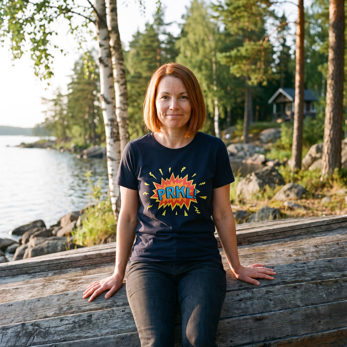 PRKL Bang organic t-shirt in french navy, worn by Sanna on an upturned rowing boat, Very Finnish Problems