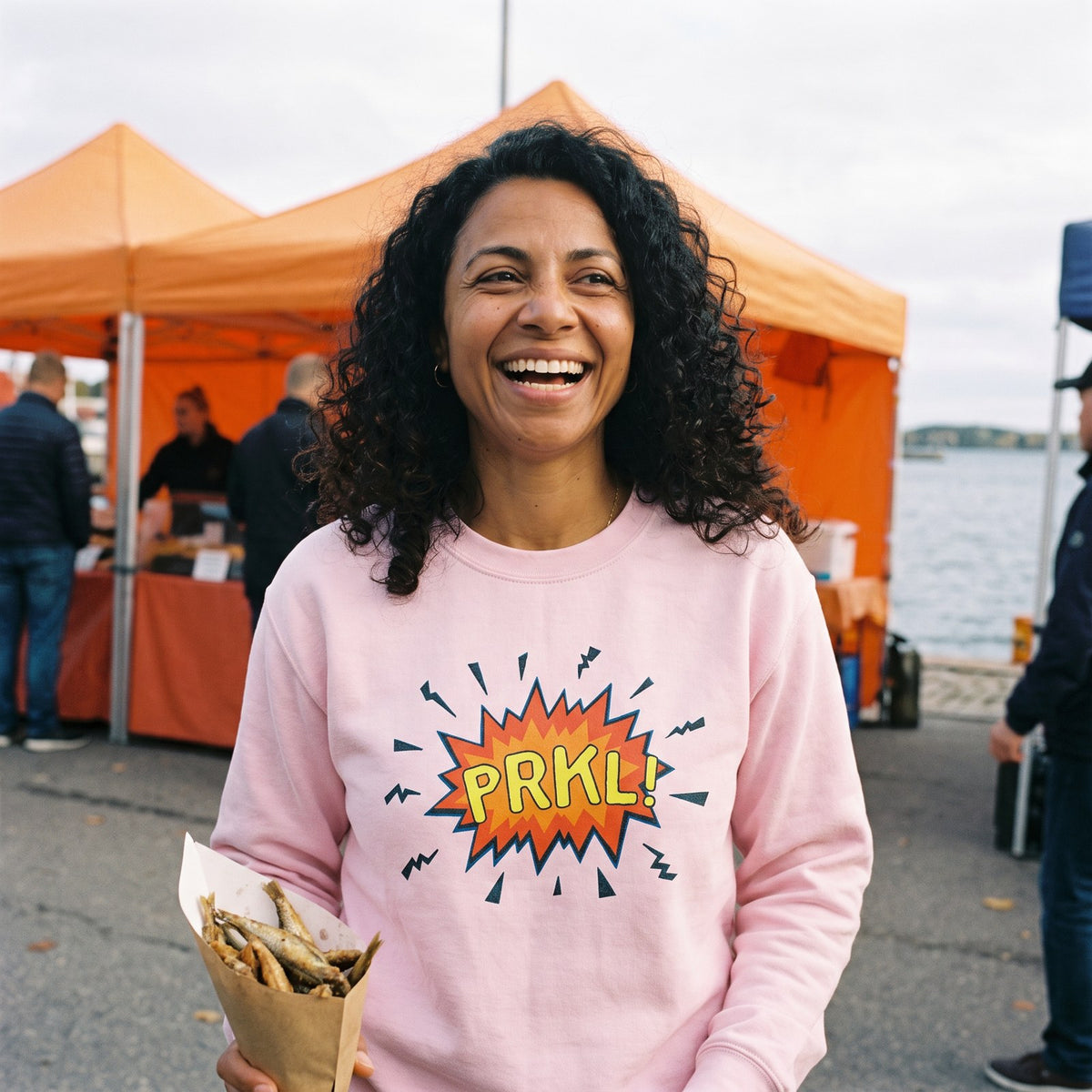 PRKL Bang sweatshirt in light pink, worn by Nea laughing at the Helsinki harbour market, Very Finnish Problems