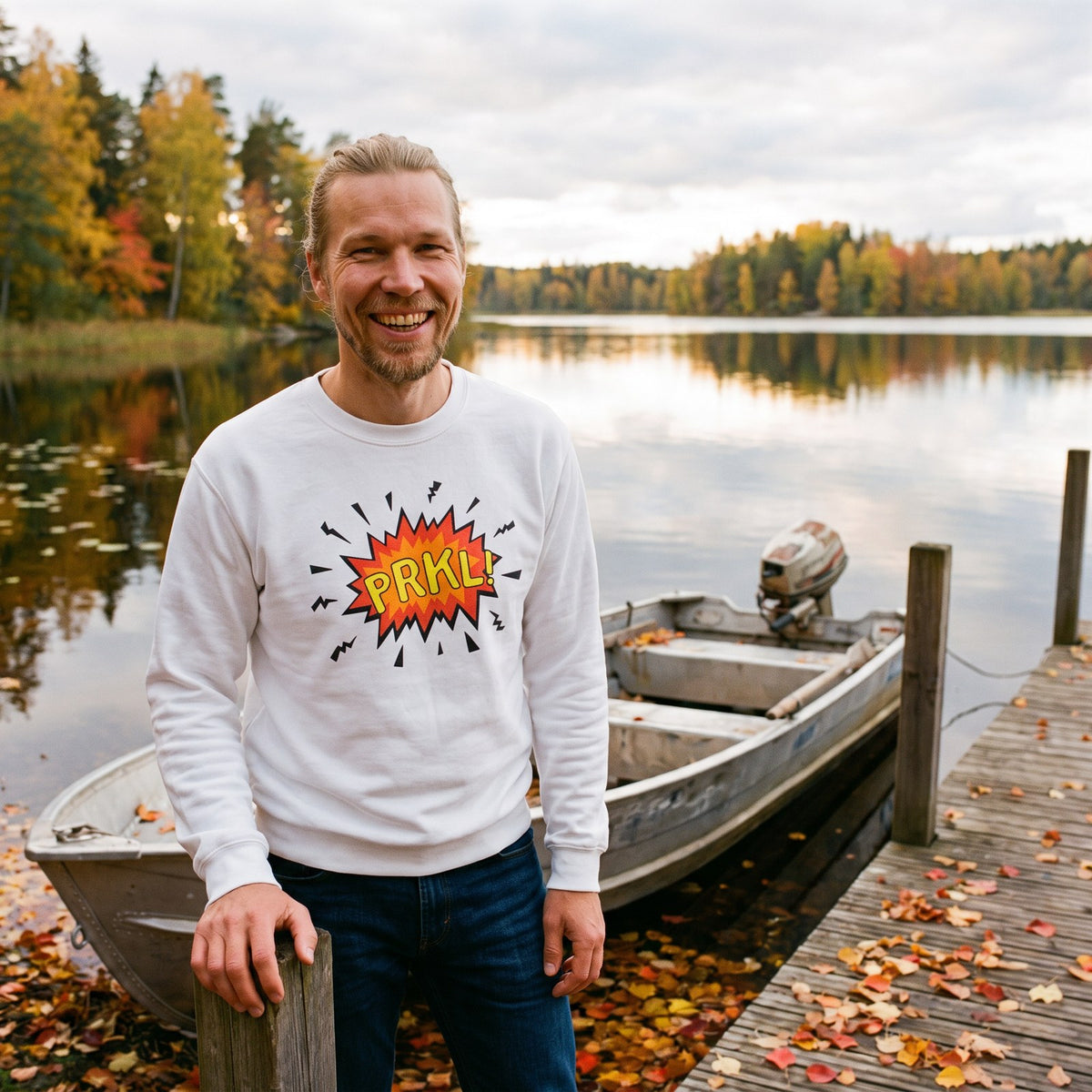 PRKL Bang sweatshirt in white, worn by Joonas on a lake jetty by a motorboat, Very Finnish Problems