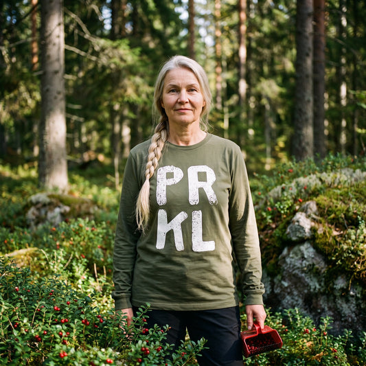 PRKL long sleeve tee in military green, worn by Anneli picking lingonberries in a spruce forest, Very Finnish Problems