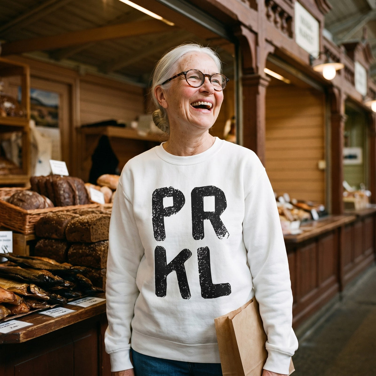 PRKL sweatshirt in white, worn by Raija laughing in an old market hall, Very Finnish Problems
