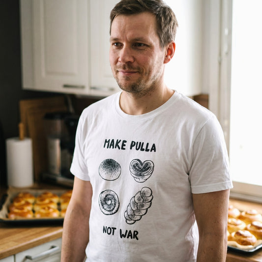 Man in a Finnish kitchen wearing the white Make Pulla Not War t-shirt, full print visible, Very Finnish Problems