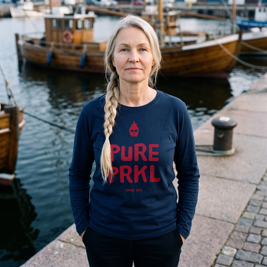 Pure PRKL long sleeve tee in navy, worn by Anneli beside harbour rowing boats, Very Finnish Problems