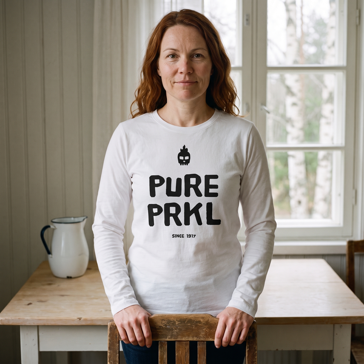 Pure PRKL long sleeve tee in white, worn by Sanna at a Finnish kitchen table, Very Finnish Problems