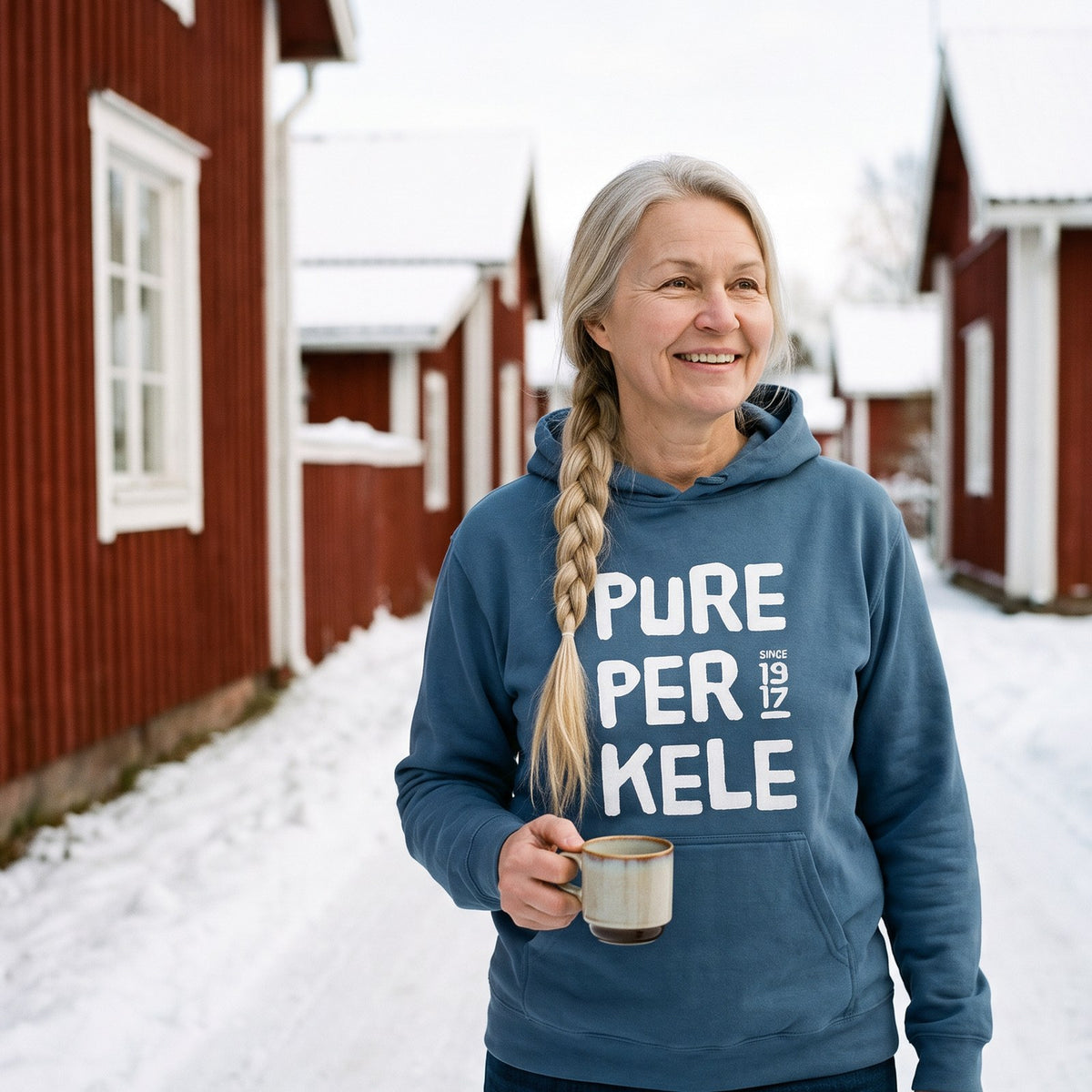 Pure Perkele since 1917 hoodie in indigo blue, worn by Anneli in a snowy village lane, Very Finnish Problems