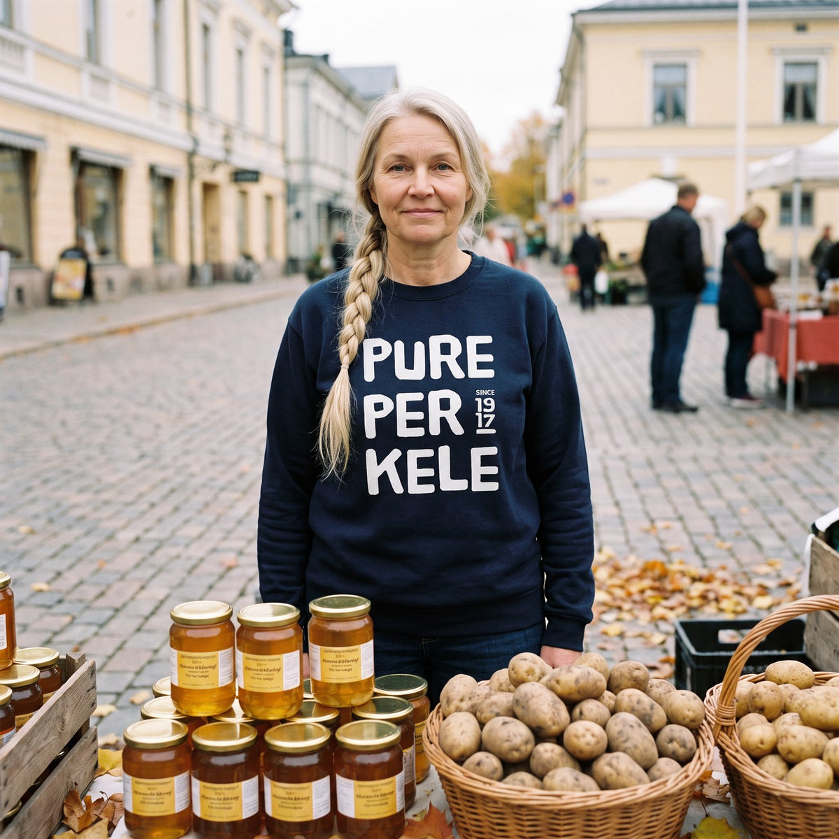 Pure Perkele since 1917 sweatshirt in navy, worn by Anneli at a farmers market stall, Very Finnish Problems