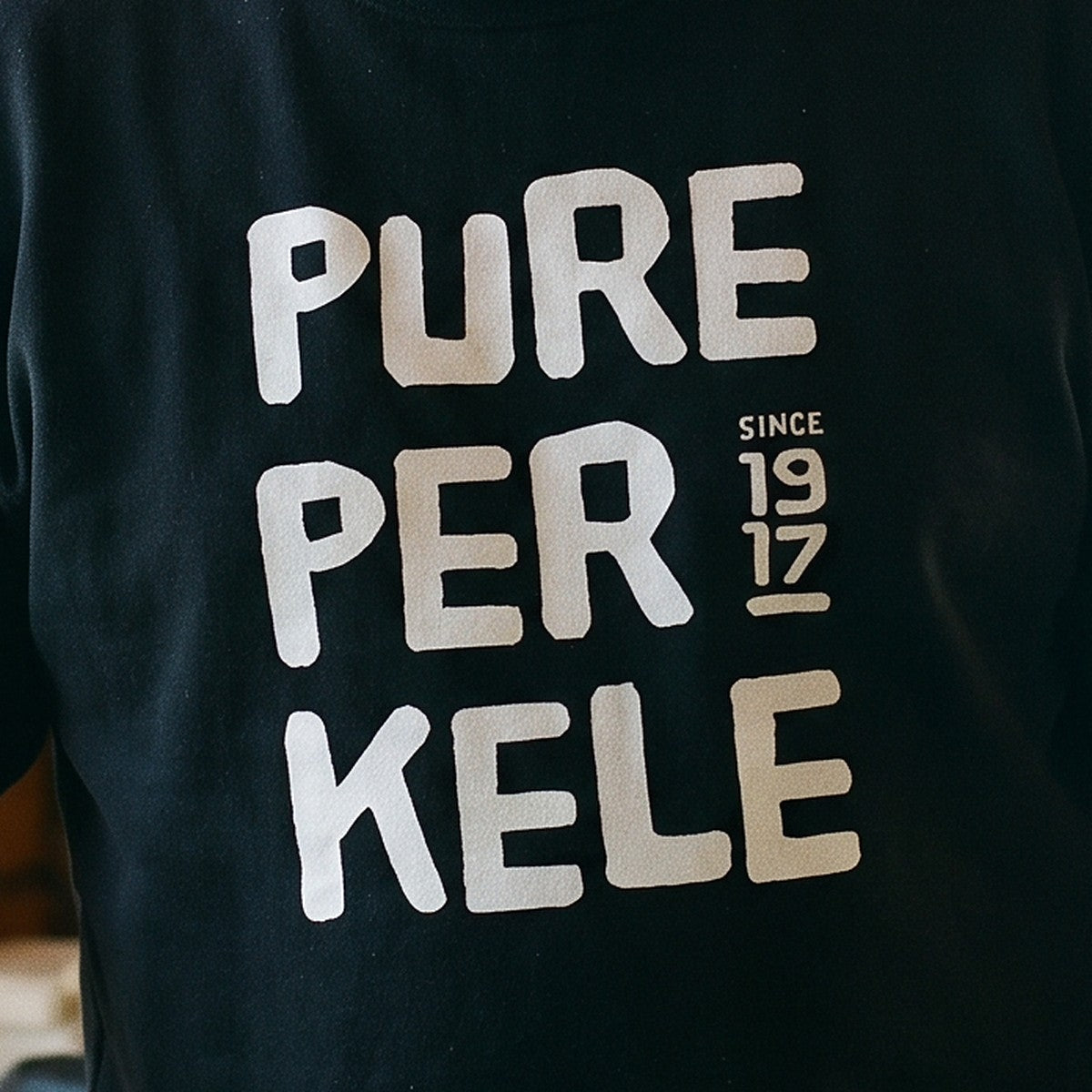 Close-up of the Pure Perkele since 1917 print on black sweatshirt fabric, Very Finnish Problems