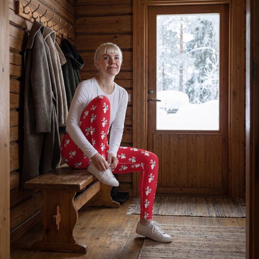 Reindeer Finnish nature yoga leggings, worn by Venla lacing a trainer in a wooden hallway, Very Finnish Problems