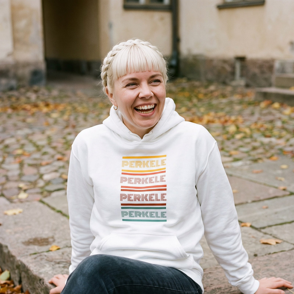 Retro Perkele hoodie in white, worn by Venla in an old town courtyard, Very Finnish Problems