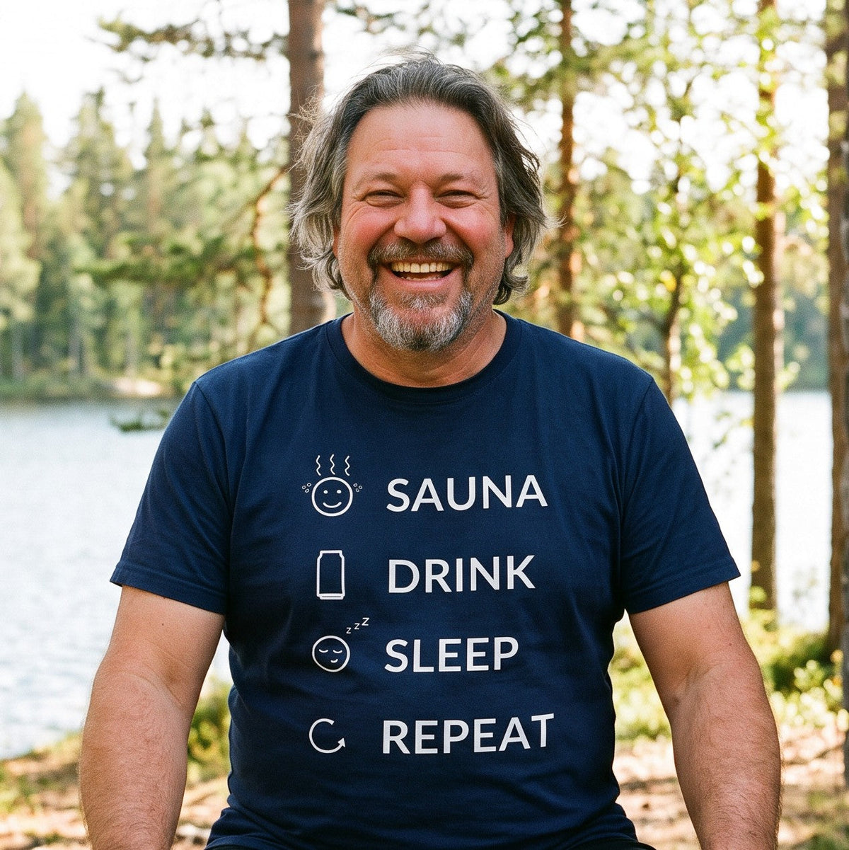 Sauna Drink Sleep Repeat t-shirt in navy, worn by Jojelli grinning on a bench outside a lakeside cabin, Very Finnish Problems