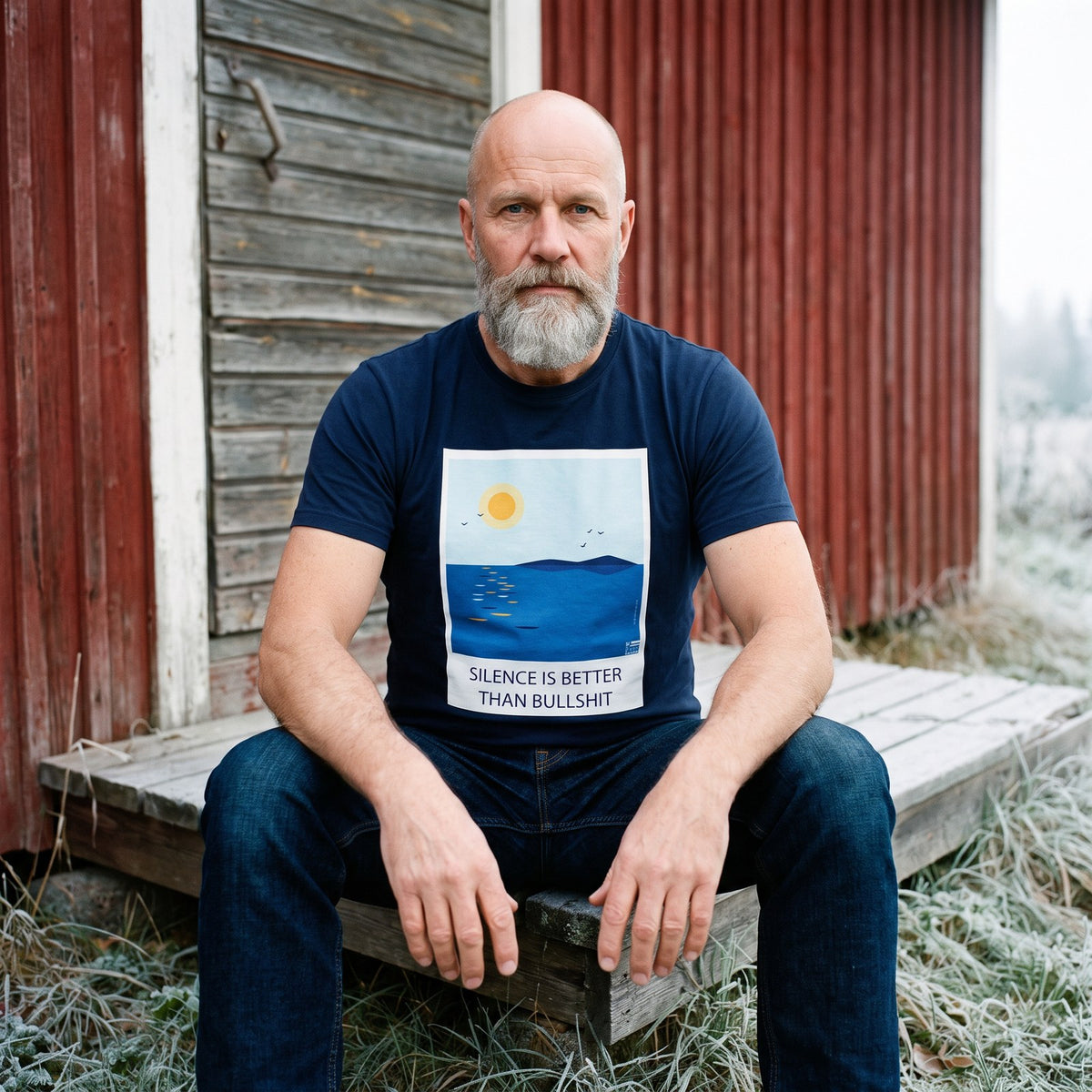Silence Is Better Than Bullshit organic t-shirt in french navy, worn by Mikko by a red barn in a frosty field, Very Finnish Problems