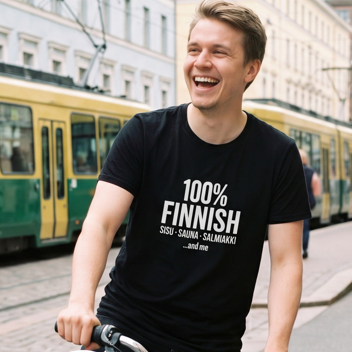 Man cycling past a Helsinki tram wearing the 100% Finnish Sisu Sauna Salmiakki t-shirt in black