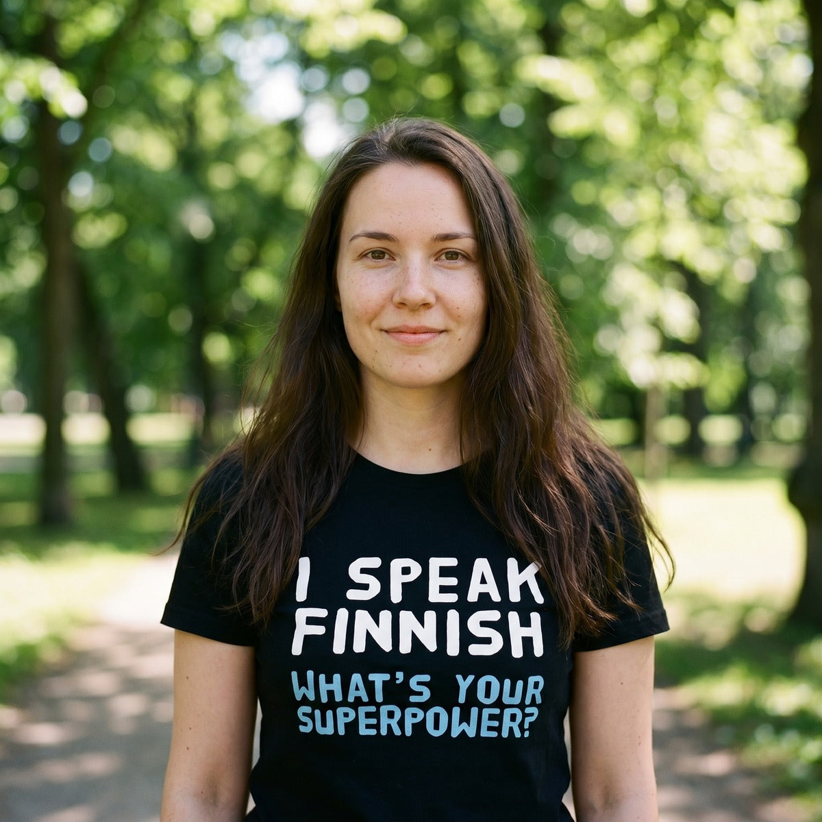 Young Finnish woman in a Helsinki park wearing the black I Speak Finnish What's Your Superpower t-shirt, Very Finnish Problems