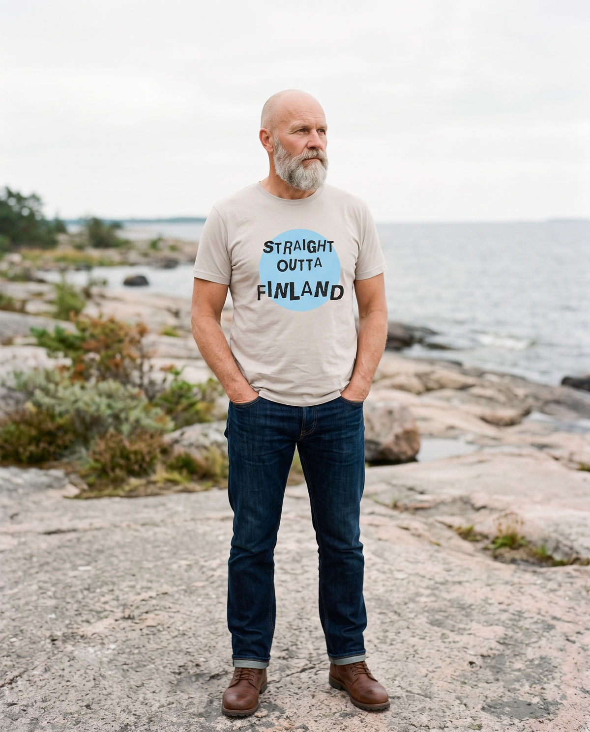 Straight Outta Finland t-shirt in ash, worn by Mikko on a granite Baltic shore, Very Finnish Problems
