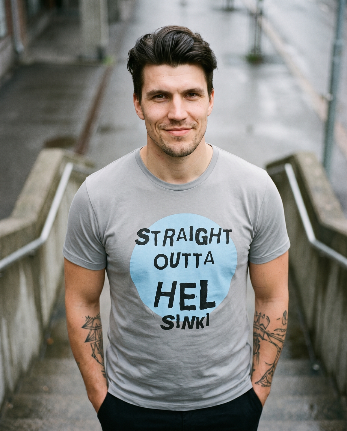 Straight Outta Hel II t-shirt in silver, worn by Eetu on a concrete stairway, Very Finnish Problems