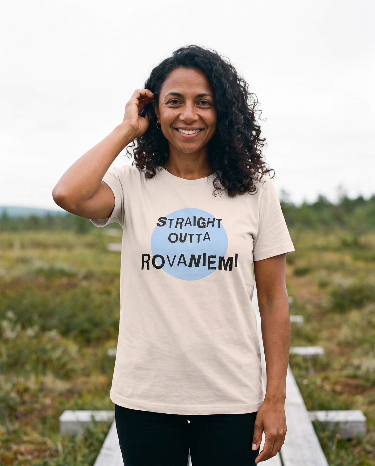 Straight Outta Rovaniemi t-shirt in ash, worn by Nea on a Lapland boardwalk, Very Finnish Problems