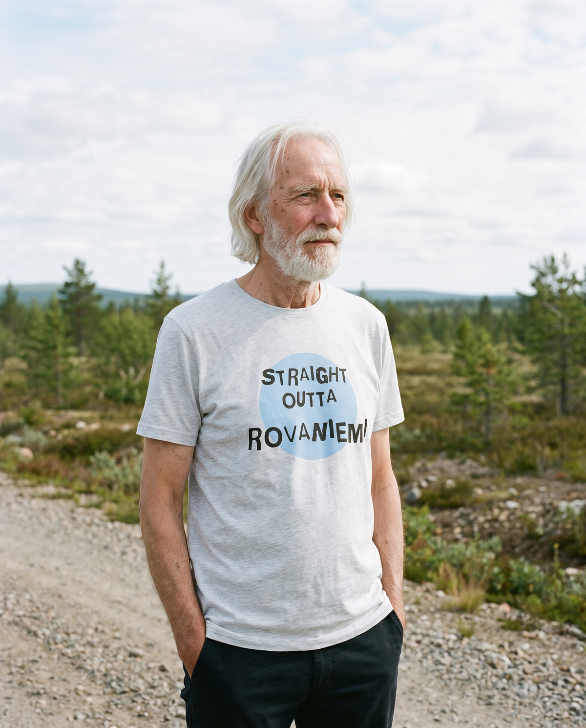 Straight Outta Rovaniemi t-shirt in athletic heather grey, worn by Pertti on a Lapland gravel track, Very Finnish Problems