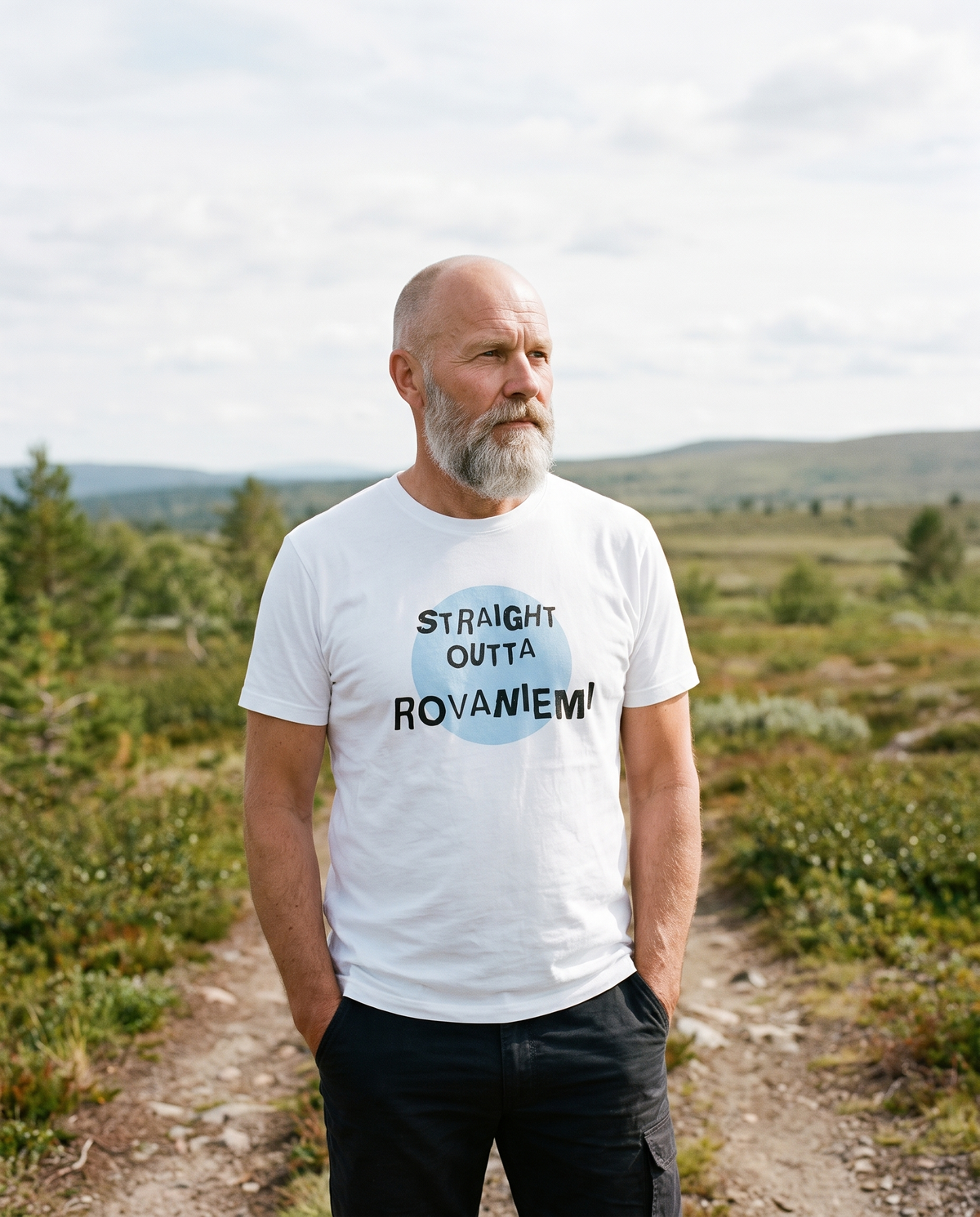 Straight Outta Rovaniemi t-shirt in white, worn by Mikko on a Lapland fell path, Very Finnish Problems