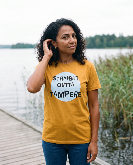 Straight Outta Tampere t-shirt in gold, worn by Nea on a lakeside boardwalk, Very Finnish Problems