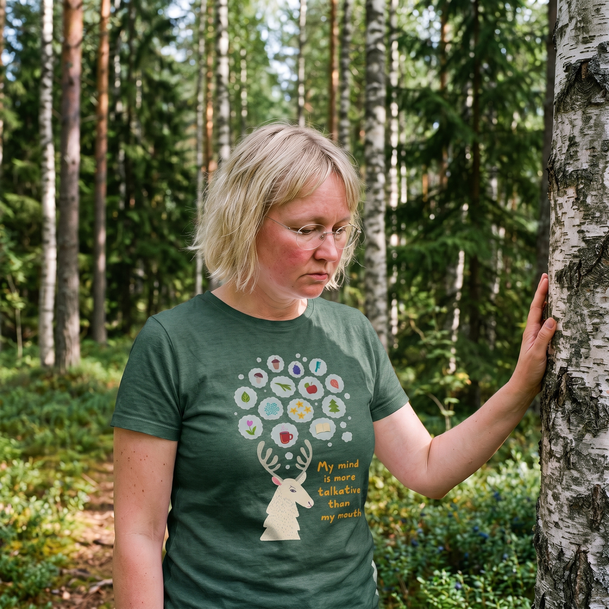 Talkative Mind t-shirt in forest green, worn by a woman resting a hand on a birch trunk, Very Finnish Problems