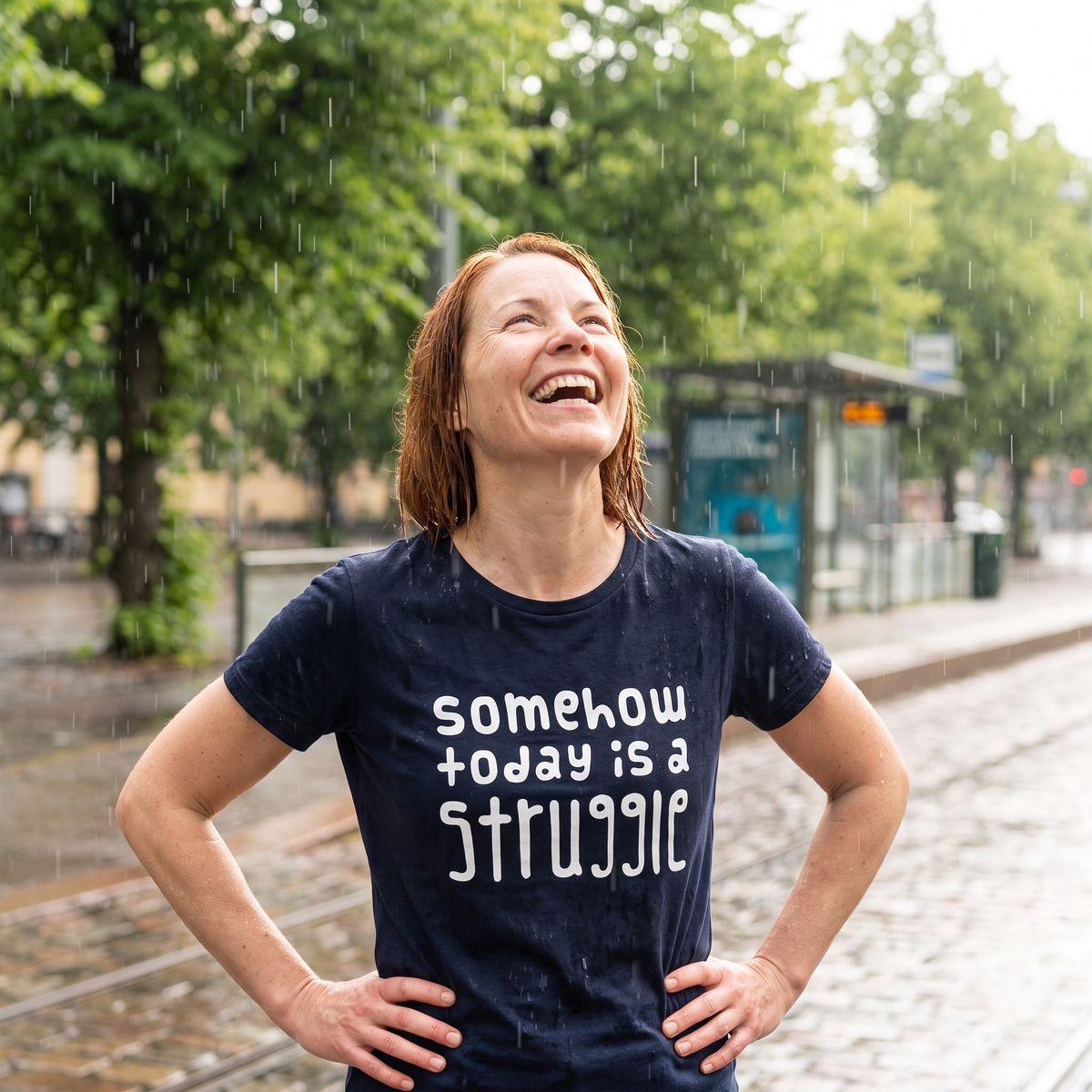 Somehow today is a struggle Finnish organic cotton t-shirt in French navy, worn by Sanna laughing in a summer downpour, Very Finnish Problems