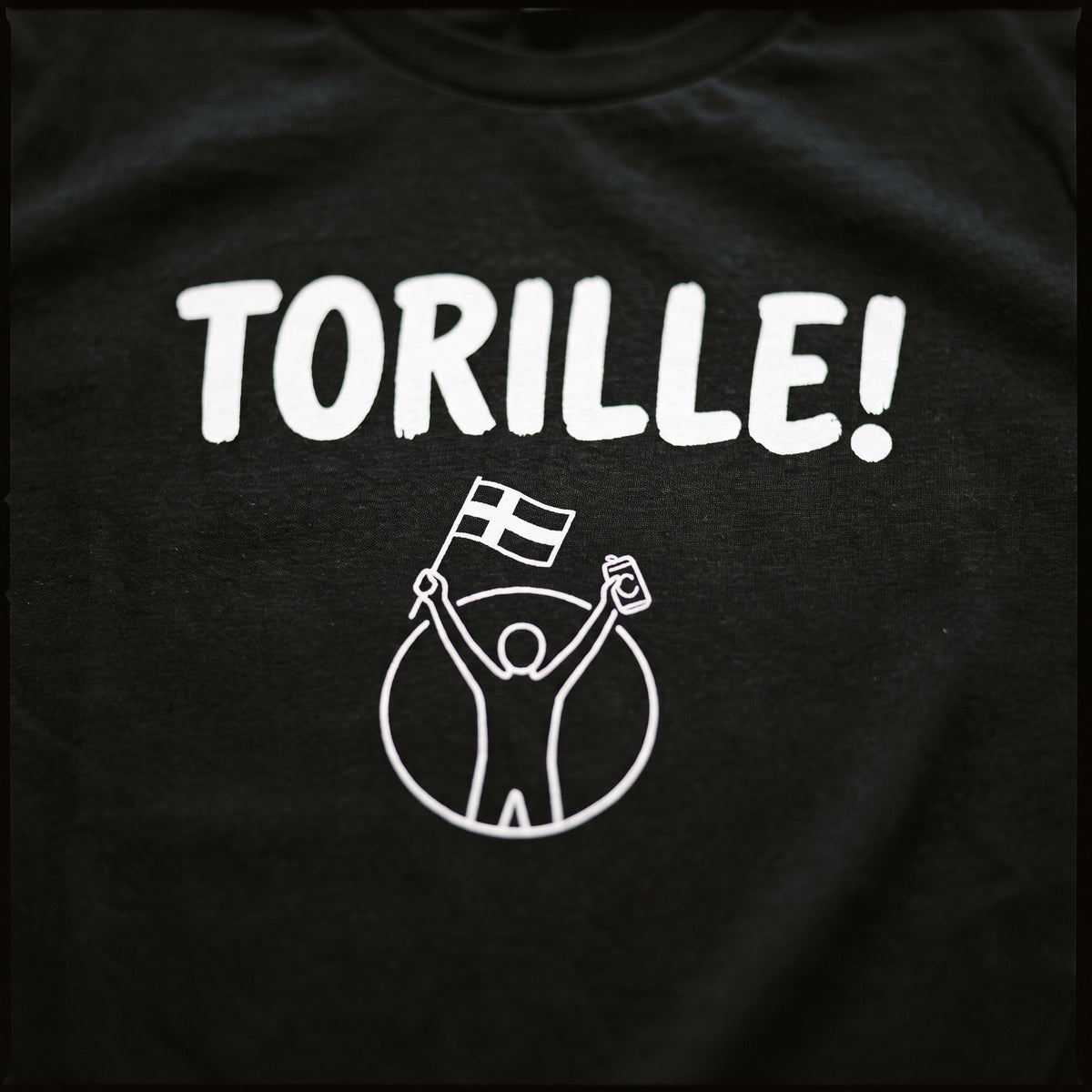 Close up of the white Torille print on black cotton, showing the fabric weave through the ink, Very Finnish Problems