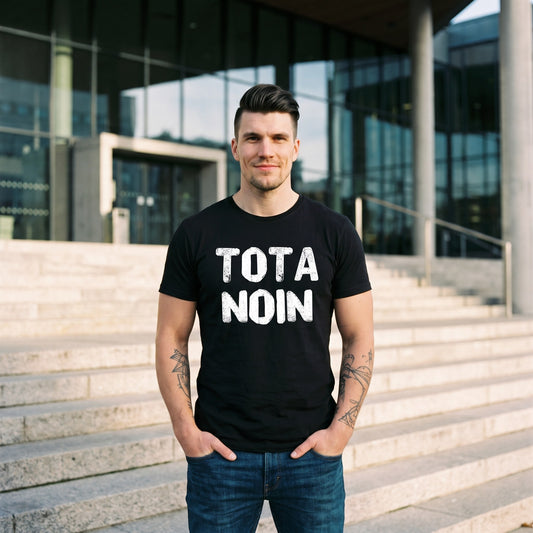 Tota noin Finnish language t-shirt in black, worn by a man with his hands in his pockets on library steps, Very Finnish Problems