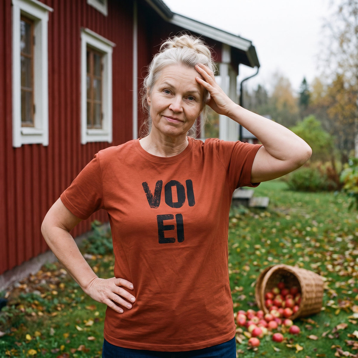 Voi ei Finnish language t-shirt in burnt orange, worn by Anneli beside a spilled basket of apples, Very Finnish Problems