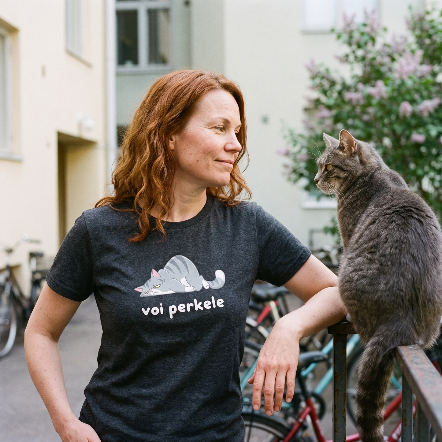 Voi perkele Cat t-shirt in dark grey heather, worn by Sanna in a Helsinki courtyard beside a cat ignoring her, Very Finnish Problems
