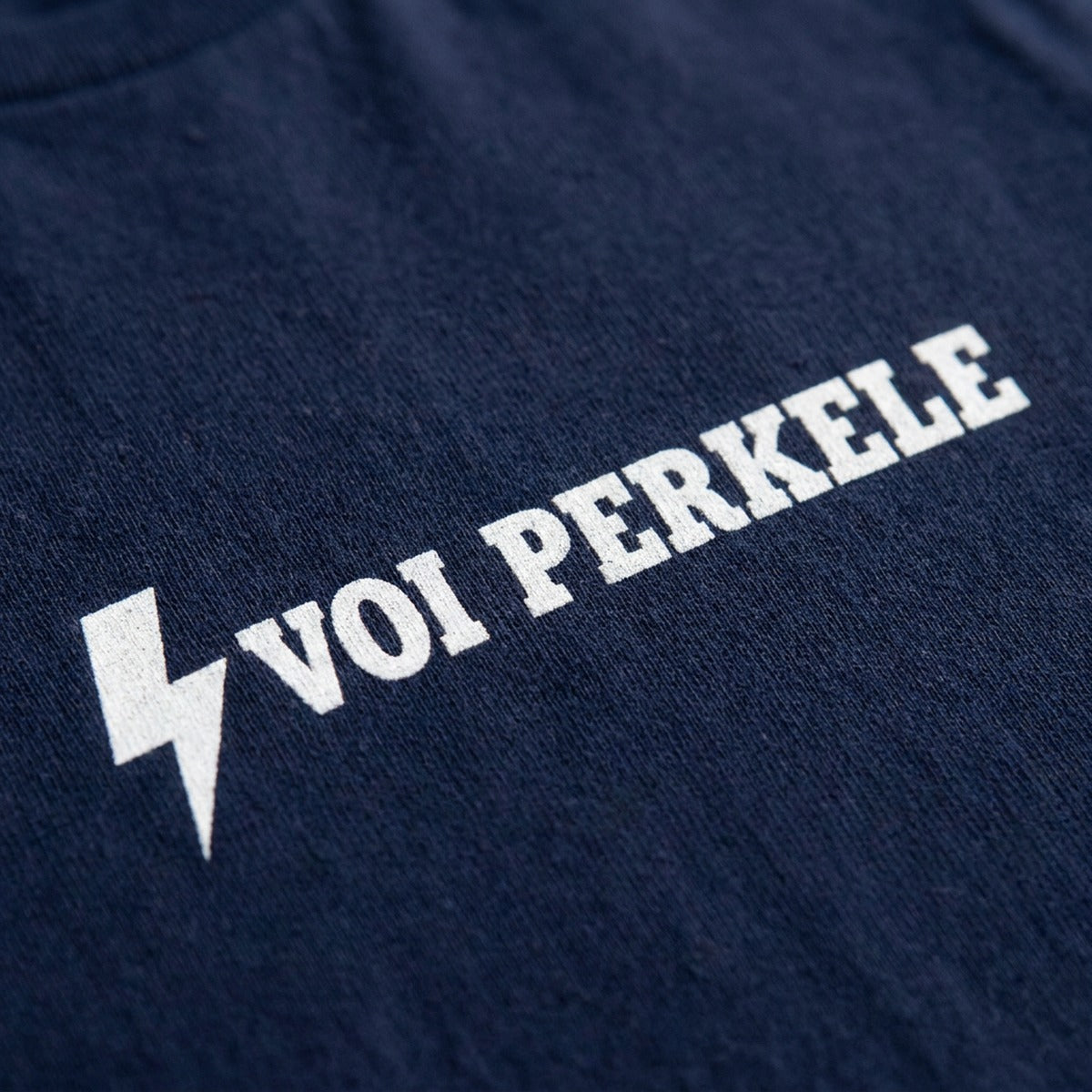 Close-up of the Voi perkele lightning bolt print on black t-shirt fabric, Very Finnish Problems