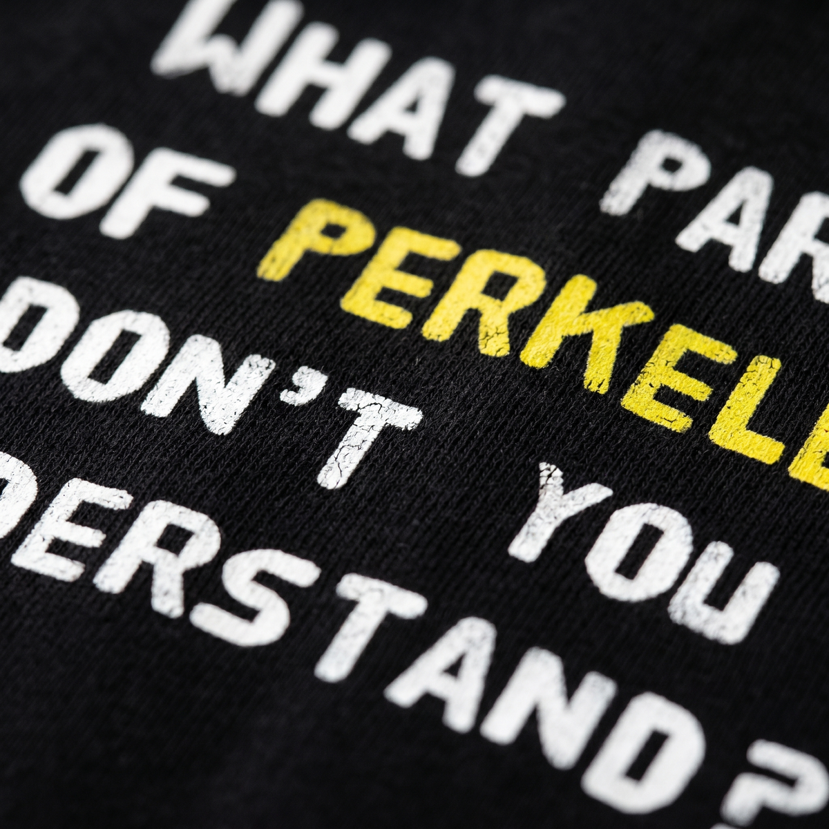 Close-up of the What part of perkele print on black t-shirt fabric, Very Finnish Problems