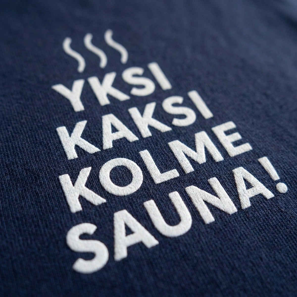 Close up of the Yksi kaksi kolme sauna print on navy t-shirt fabric by Very Finnish Problems
