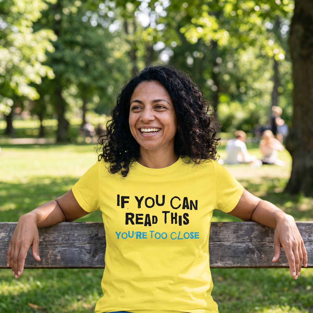 You're Too Close t-shirt in yellow, worn by Nea alone on a long park bench, Very Finnish Problems
